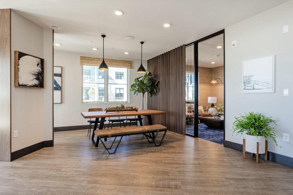 Clubhouse lounging area with table seating, wood-style flooring, and access to meeting room
