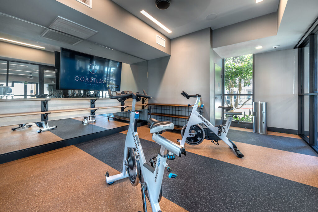Fitness spin room with bikes and a large flat screen TV